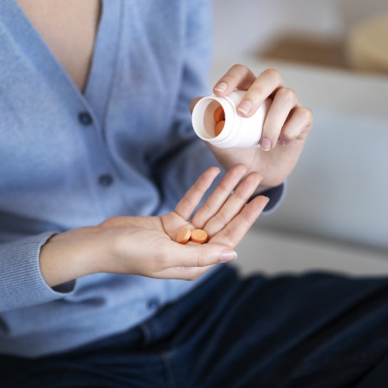 Жінка п'є таблетки