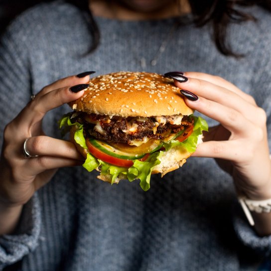 Жінка їсть бургер