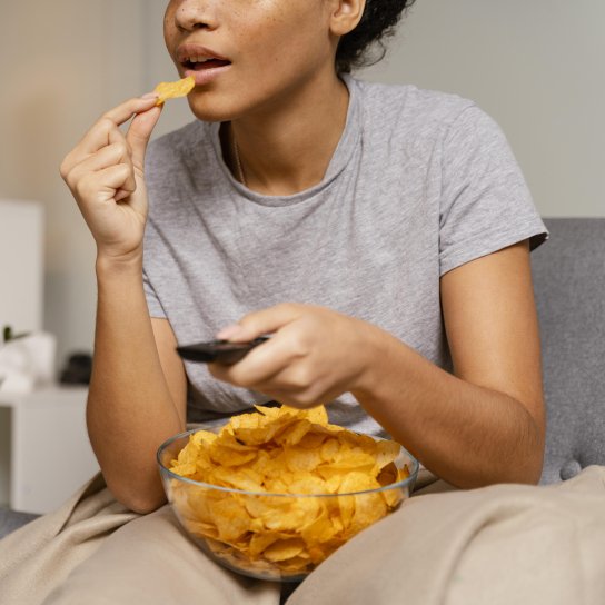 Дівчина їсть чипси