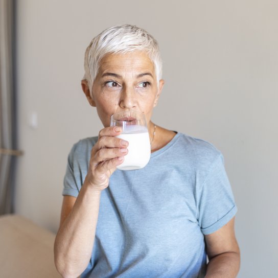 Жінка п'є йогурт