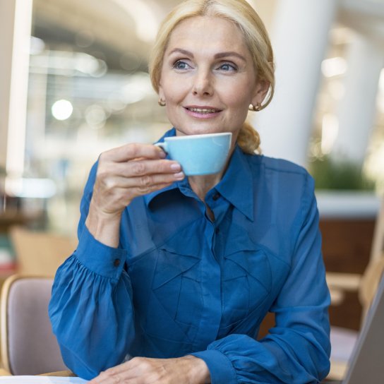 Жінка п'є каву