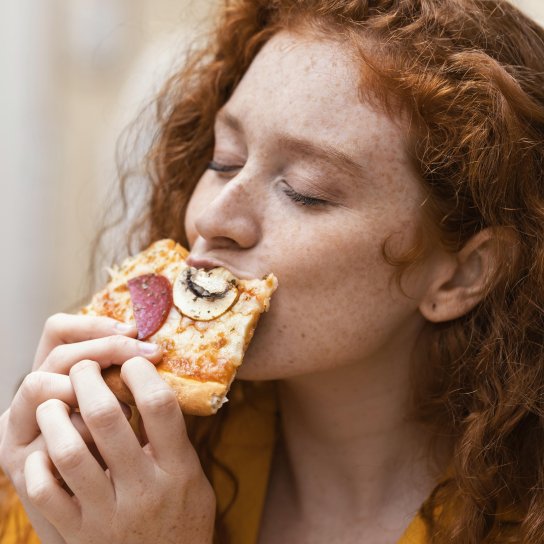 Дівчина їсть піцу