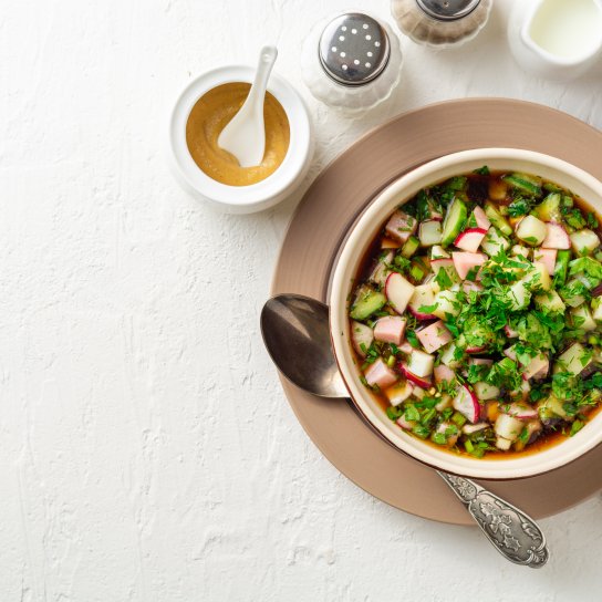 Холодний суп з кількою в томаті на тарілці на білому фоні