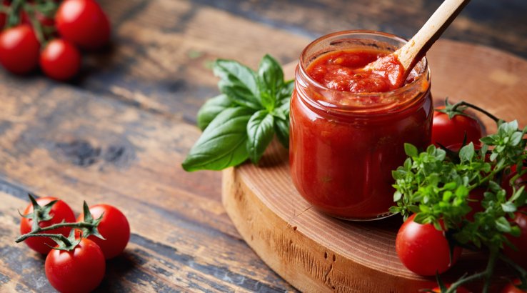Томатний соус із ложкою в скляній банці