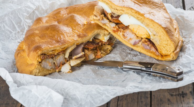 Пиріг хорназо з яйцем на пергаментному папері з ножем