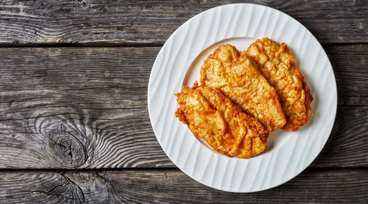 Три курячі відбивні на білій тарілці