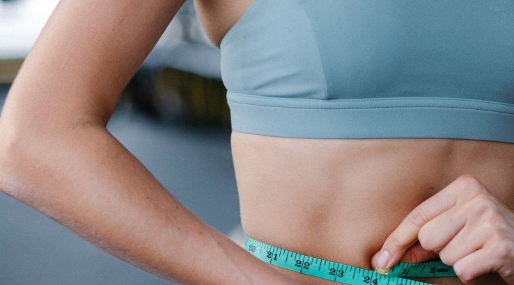 Жінка міряє обсяг талії