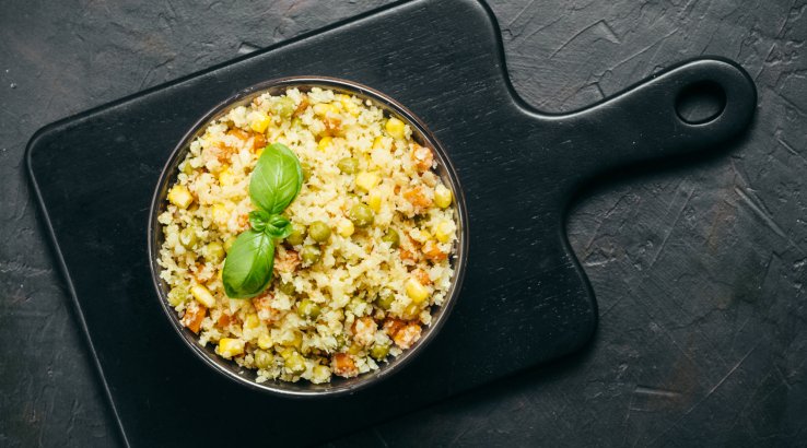 Рис з овочами та базиліком на темному фоні