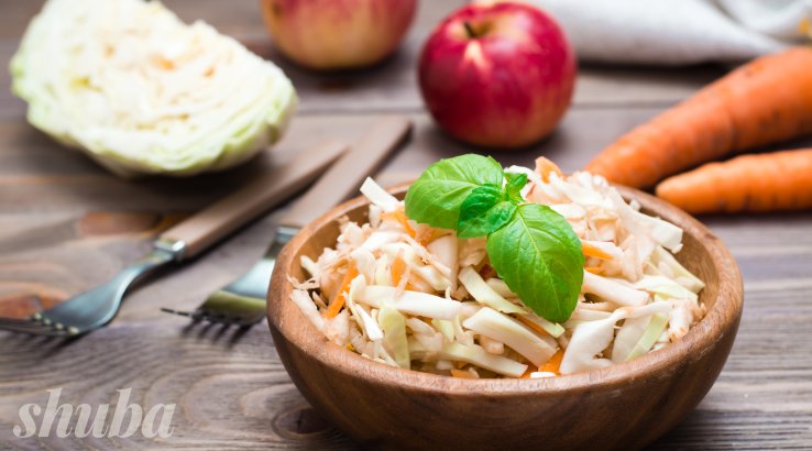 Салат з капустою, яблуком та морквою в тарілці