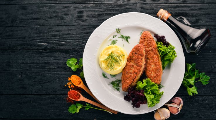 Курячі котлети з пюре із капусти на темному столі зі спеціями